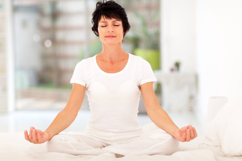 Middle aged woman meditating practicing mindfulness