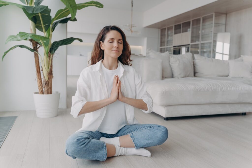 Relaxed woman practicing deep breathing and meditation to reduce stress and anxiety.