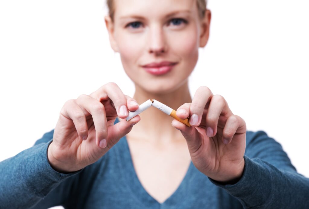 Young woman breaking a cigarette in half.