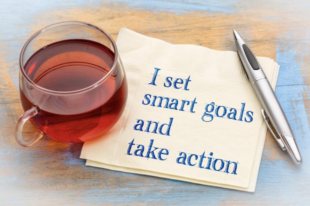 I set smart goals and take action - positive handwriting on a napkin with a cup of tea.